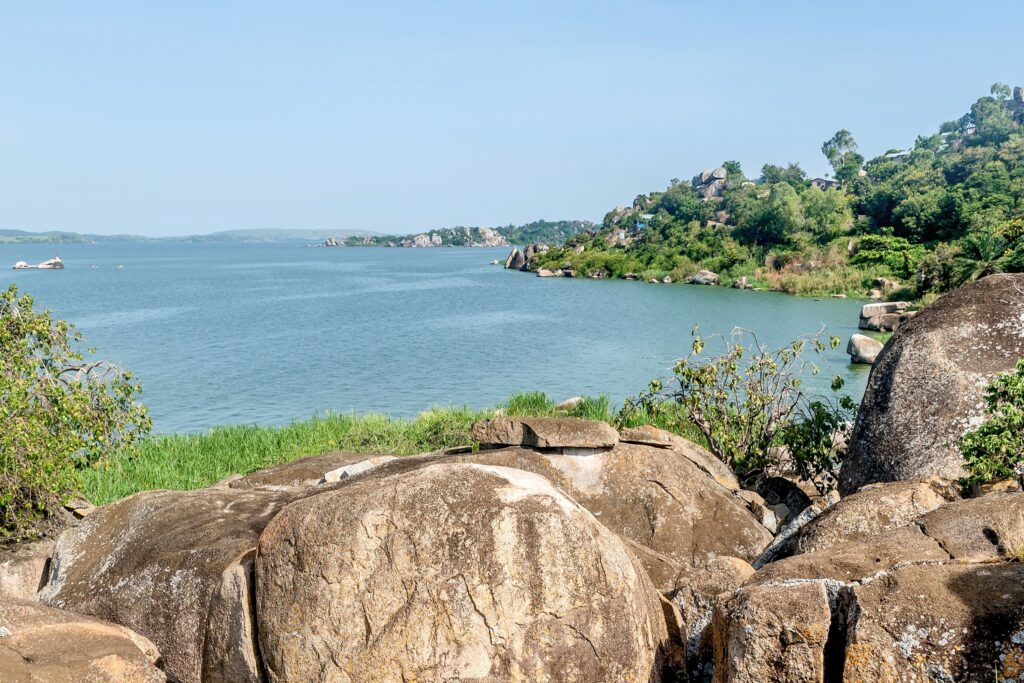 Lake Victoria with houses at the hills and big rocks in front
